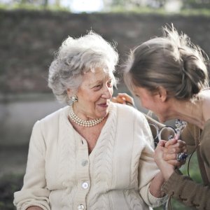Una signora anziana serena, simbolo di armonia e sostegno nelle sfide della terza età.